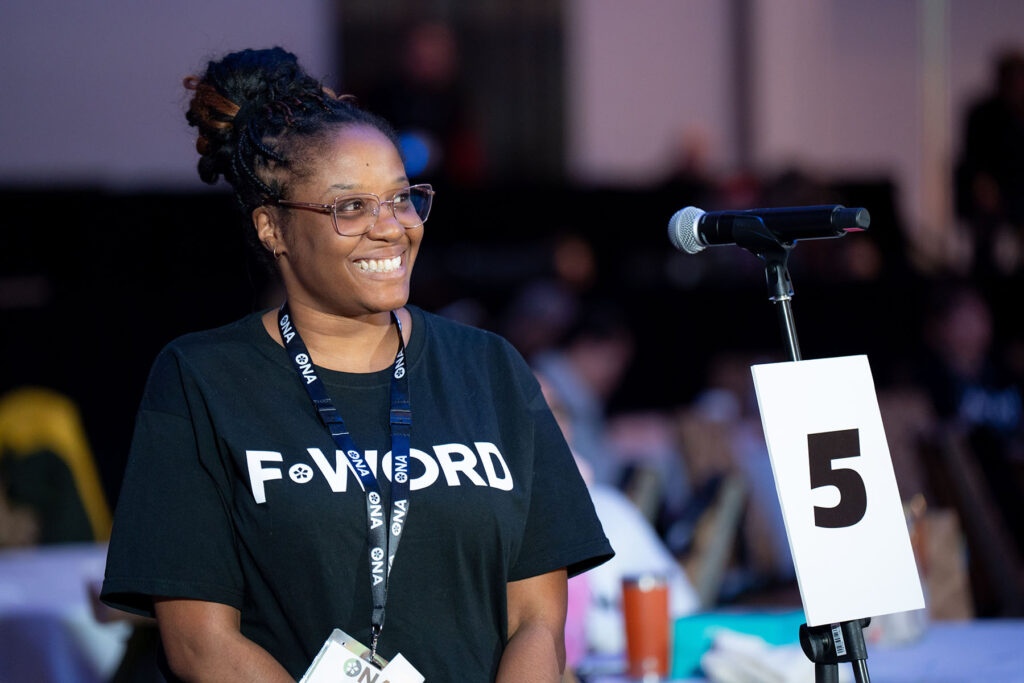 Smiling member standing at mic.