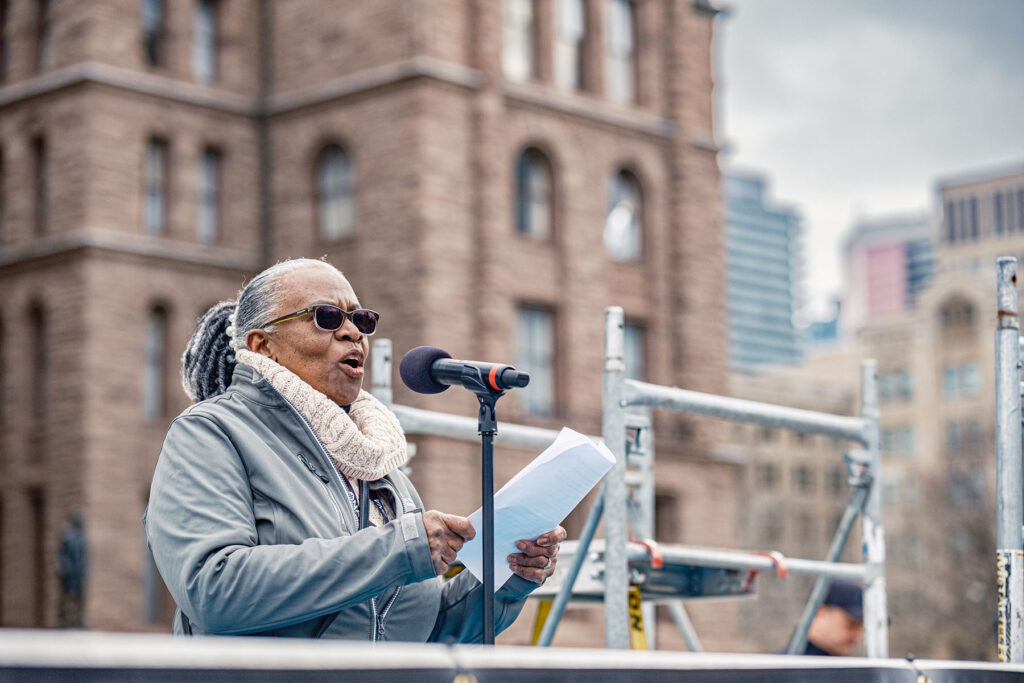 VON Provincial Negotiating Team member Lorna Thompson talks to the crowd from a flatbed truck at rally.