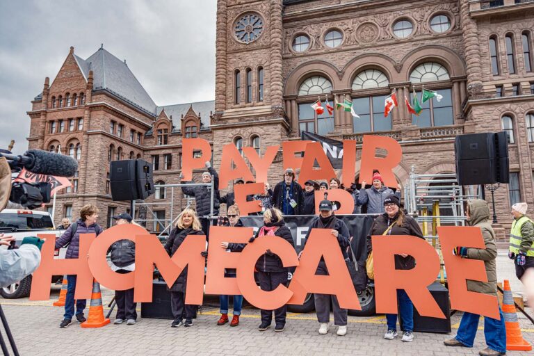 Nurses Vote secondees hold life-sized letters reading “Pay Fair for Home Care” at a large rally.