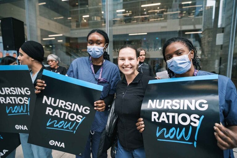 Group of members hold safe staffing signs in Toronto.