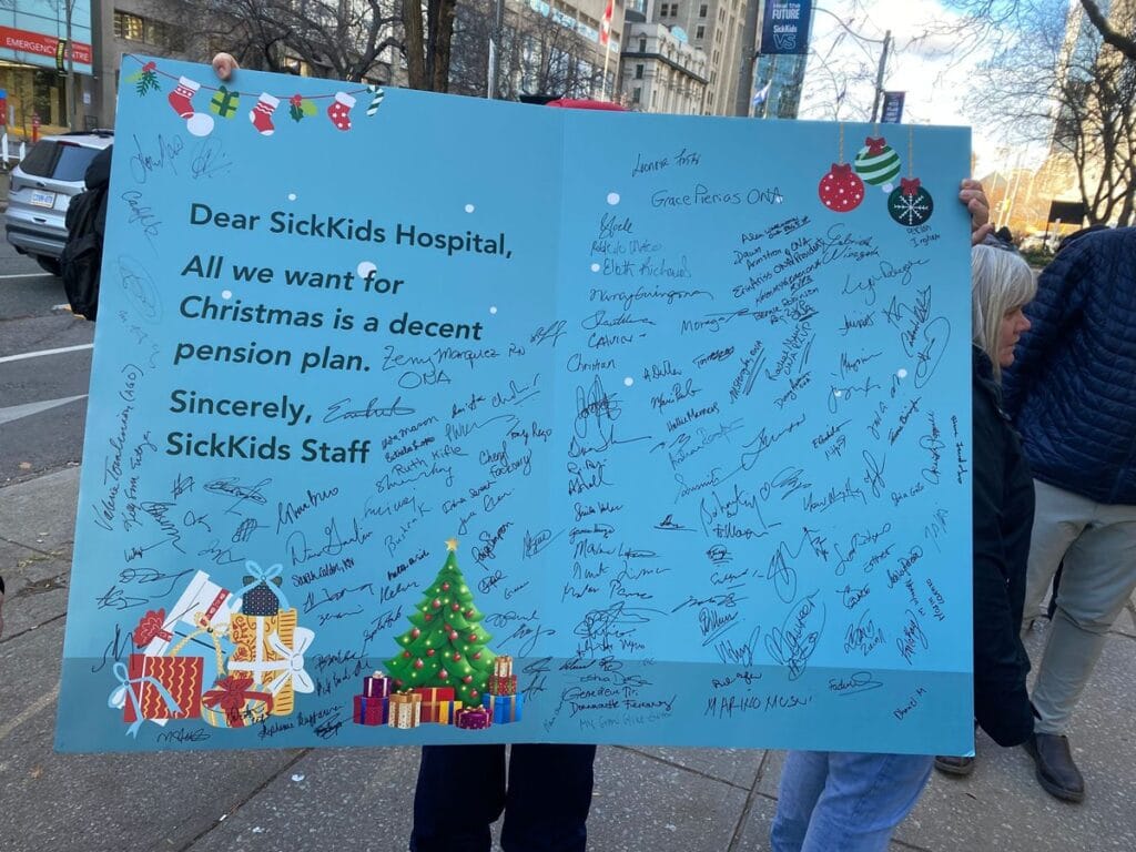 Woman holds giant signed Christmas card.