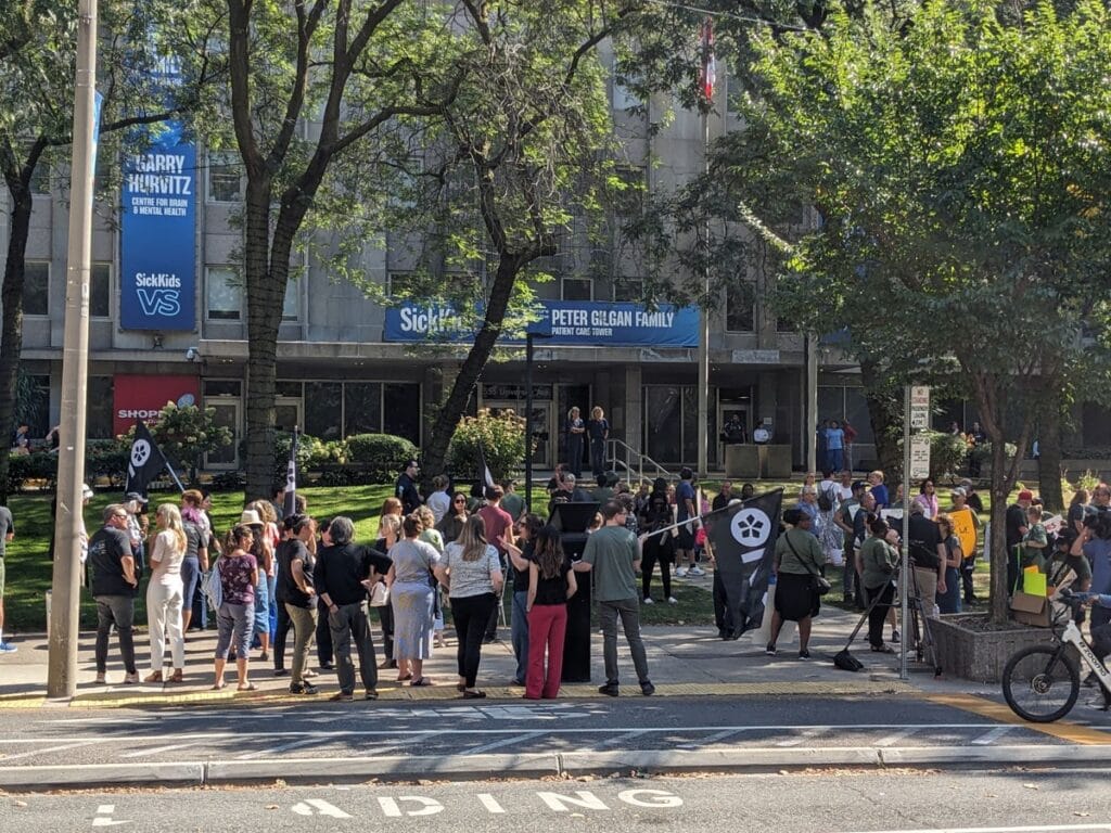 Group of members, union allies and Sickkids health-care workers across the street rally outside of hospital.