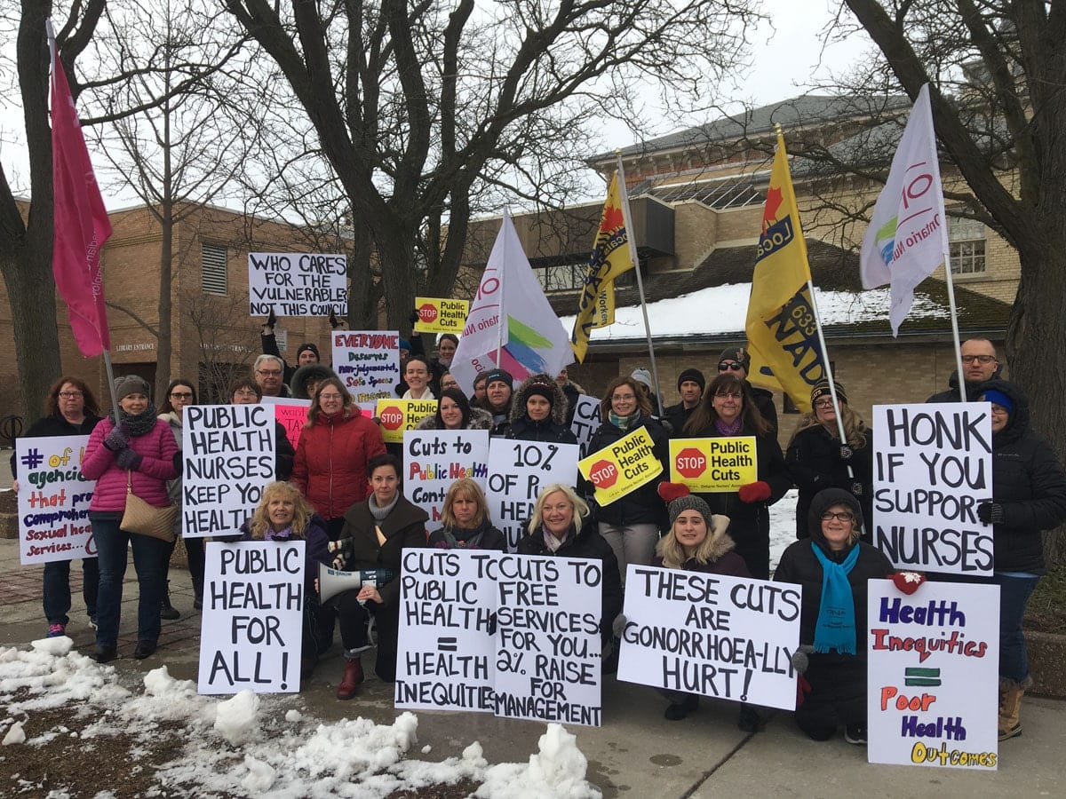 ONA7 Local Coordinator Melanie Holjak, striking members and union allies hold signs and stop to pose for camera.