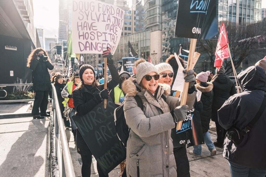 Group of members carry handmade signs.