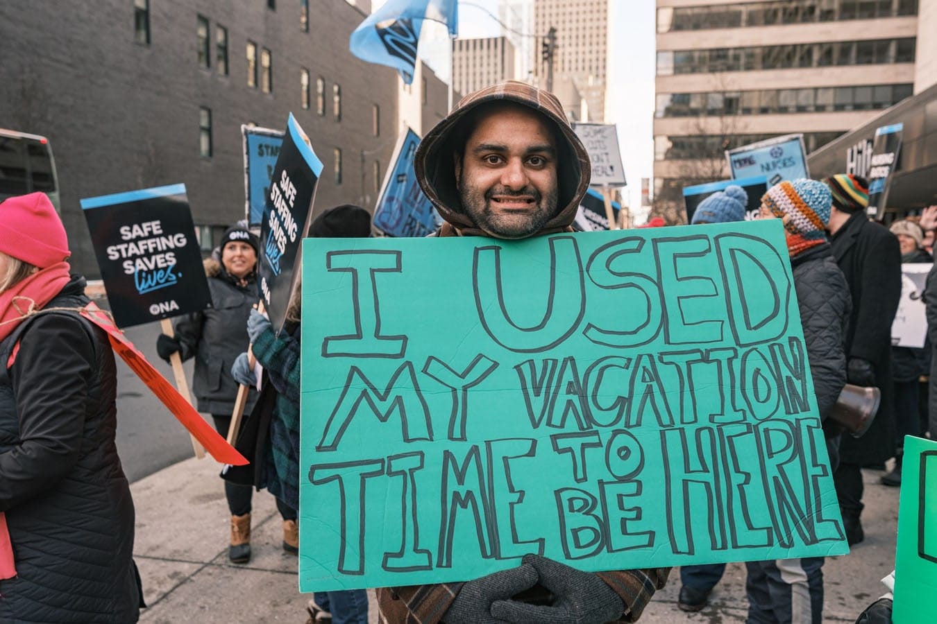 Man smiles holding handmade sign.