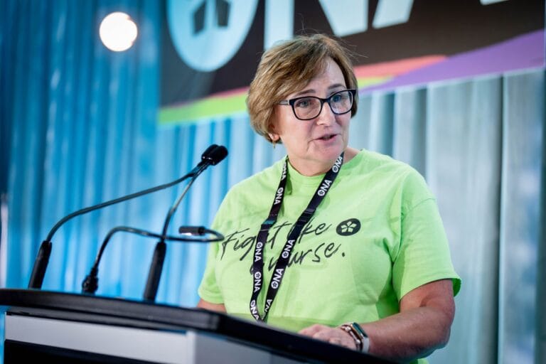 New ONA Treasurer Bernie Robinson at podium at provincial meeting addresses delegates.