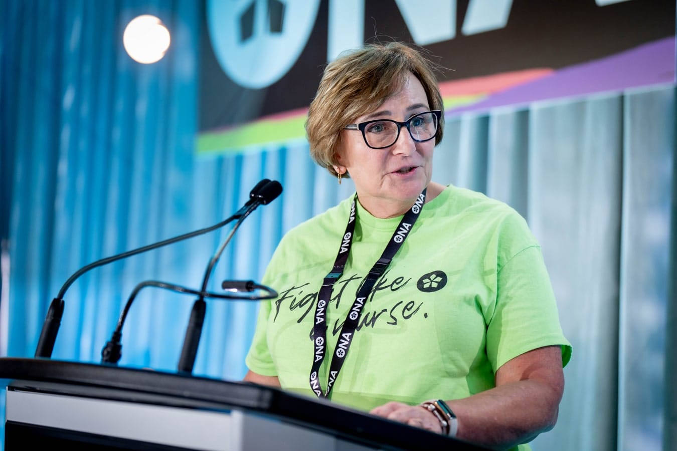 New ONA Treasurer Bernie Robinson at podium at provincial meeting addresses delegates.