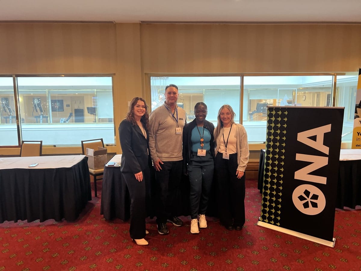 Region 5 Vice-President and First Vice-President-elect Alan Warrington and three nursing students stand in a row and smile.