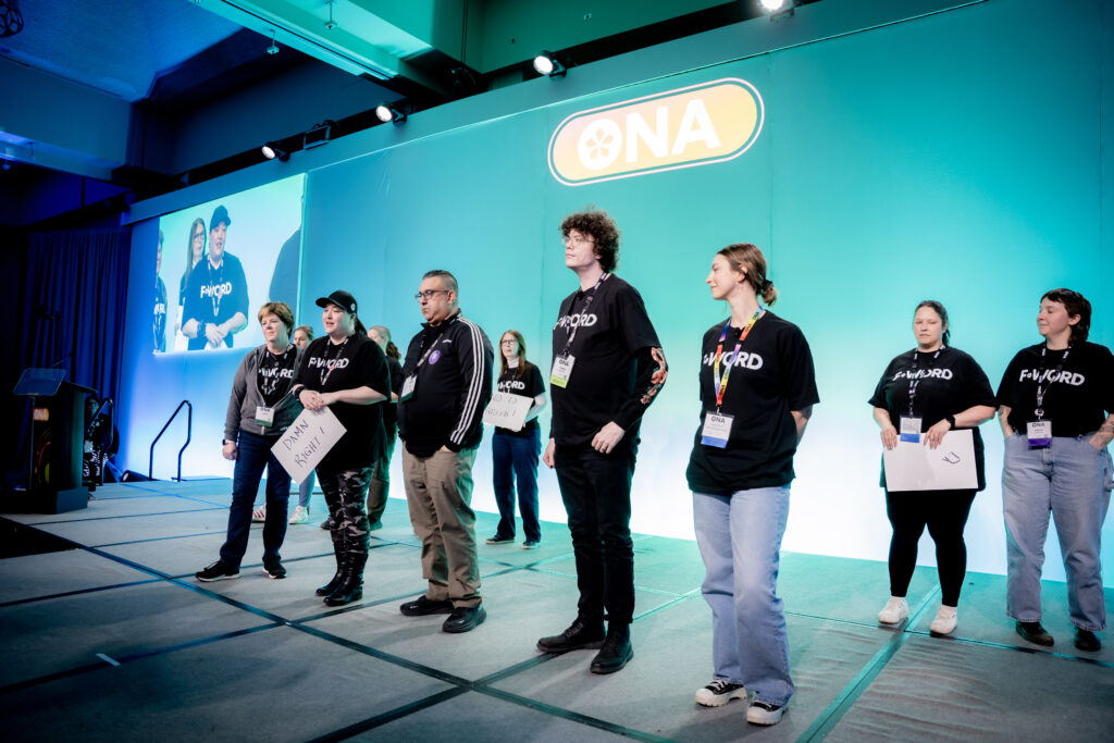 Eight people standing on a wide stage