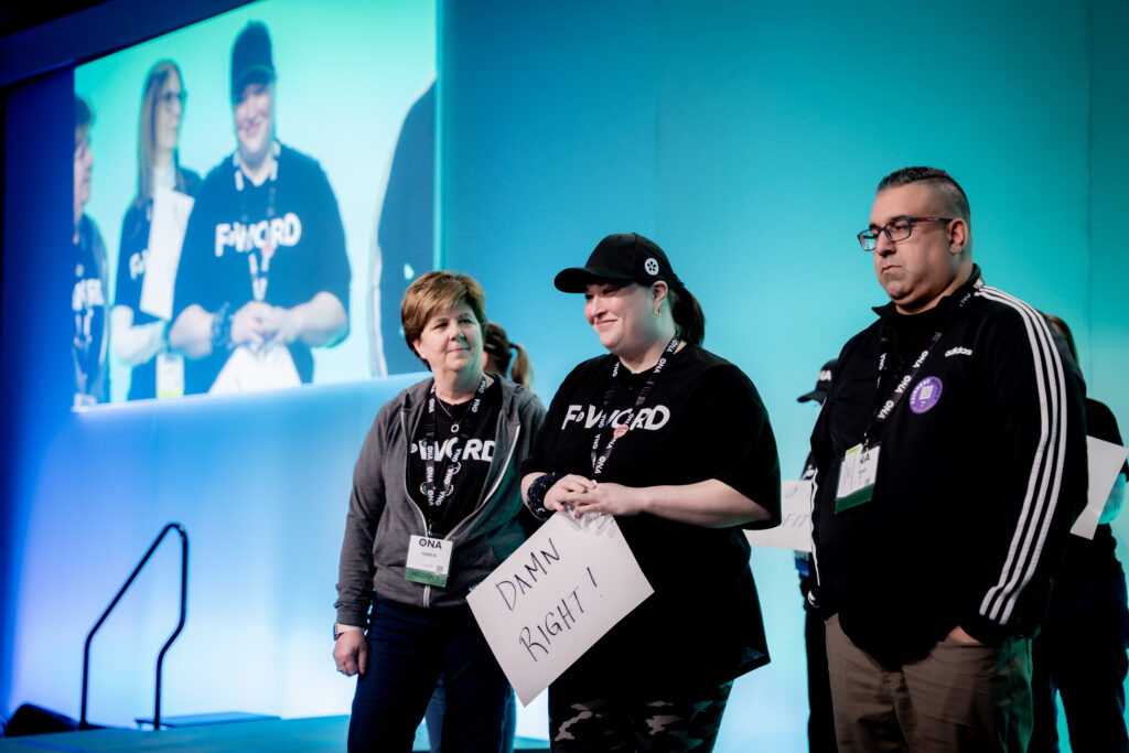 Three people standing on a stage.