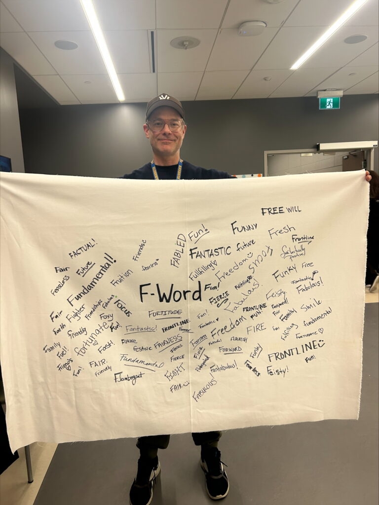 ONA member holds fabric containing many words starting with the letter f.