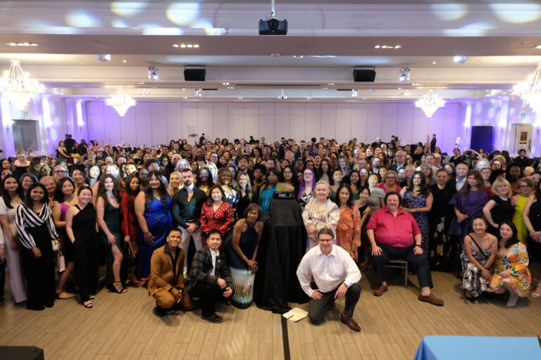 A group of people in a ballroom pose for the camera