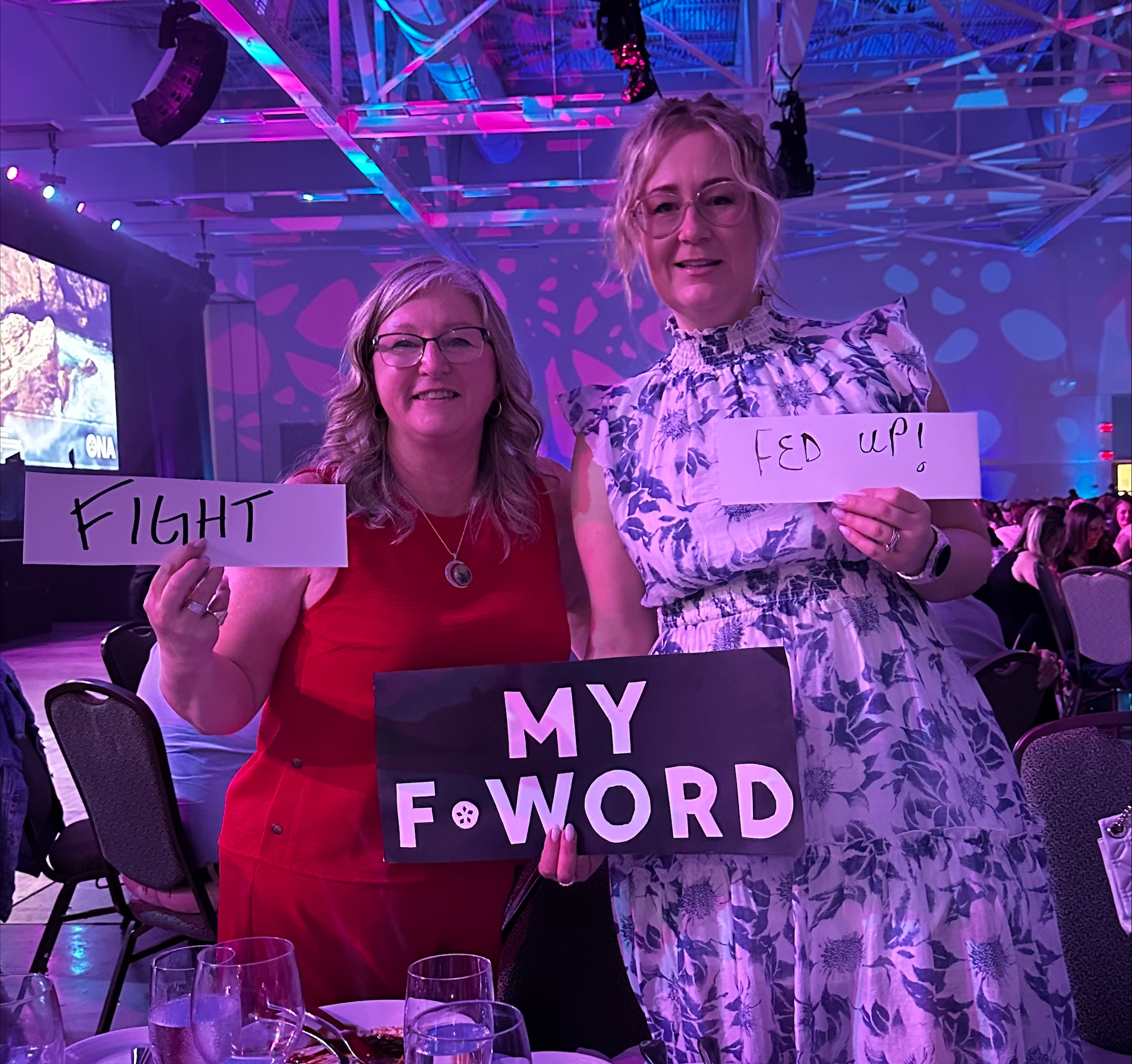 ONA124 Local Coordinator Donna Oliver and a fellow member hold signs reading, “Fight” and Fed up!”