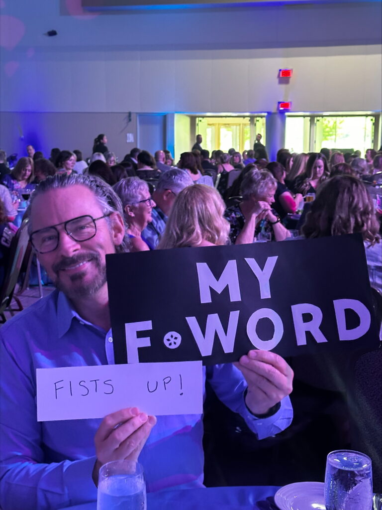 An ONA member holds a sign reading, “Fists up!”