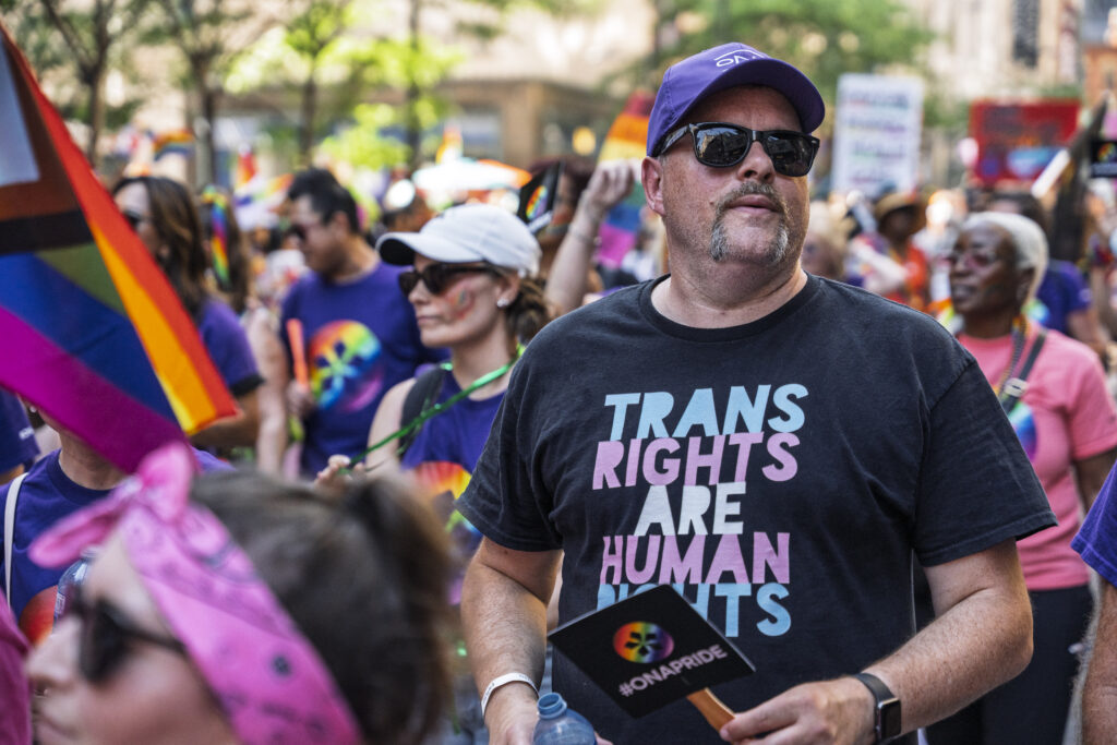 A ONA member marches in the parade wearing a shirt that says 