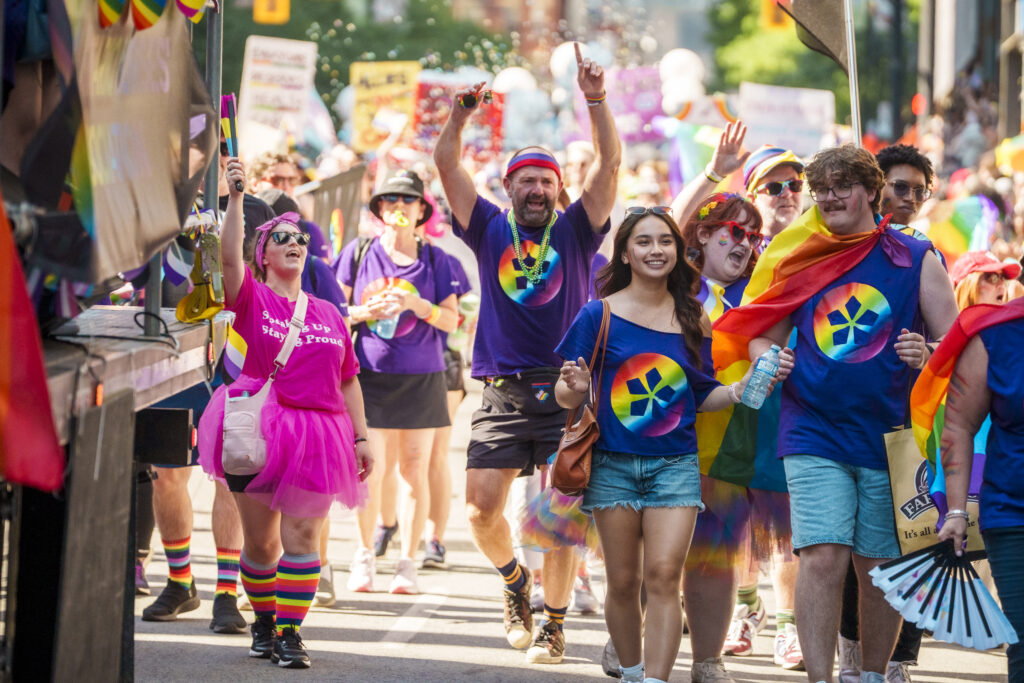 A group of ONA members smiles and waves as they march in the parade.