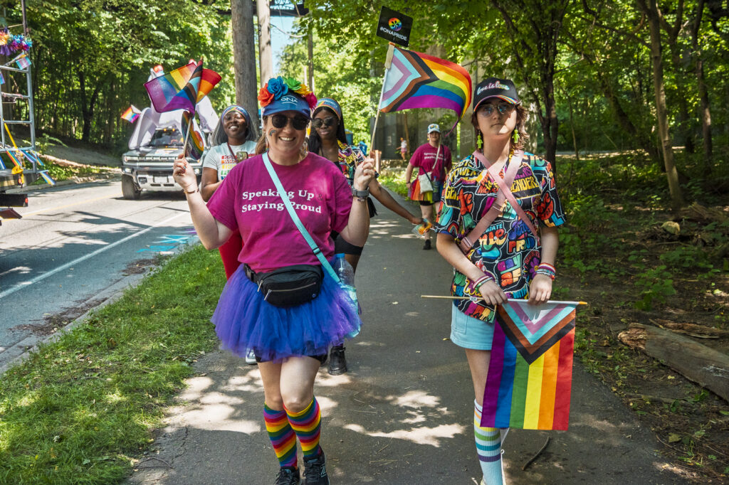 Two ONA members walk down a tree-lined road on the way to the parade.