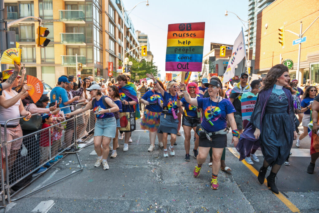A group of ONA members walks by a group of parade-watchers on Yonge Street.
