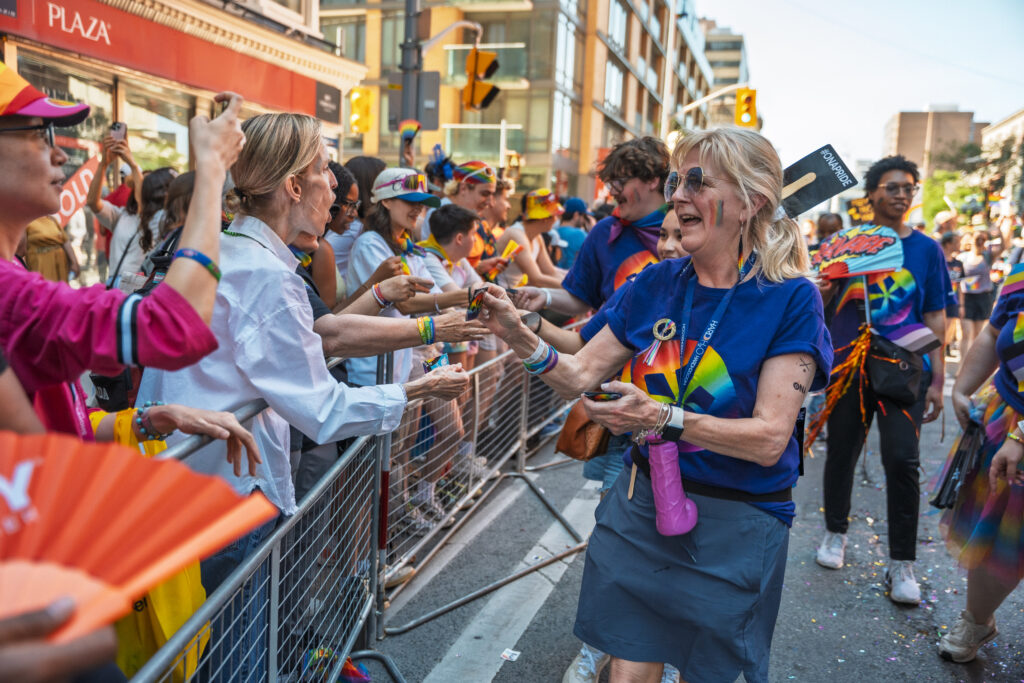An ONA member gives out stickers to parade-watchers.