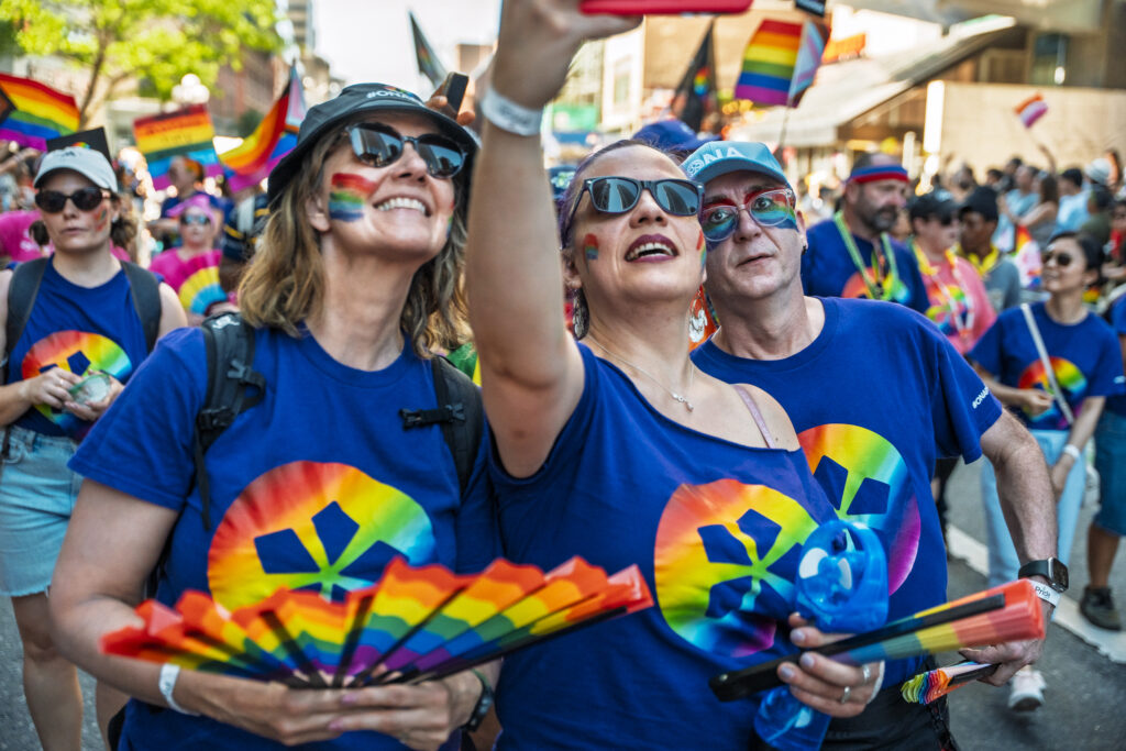 Three ONA members pose for a selfie while marching in the parade.