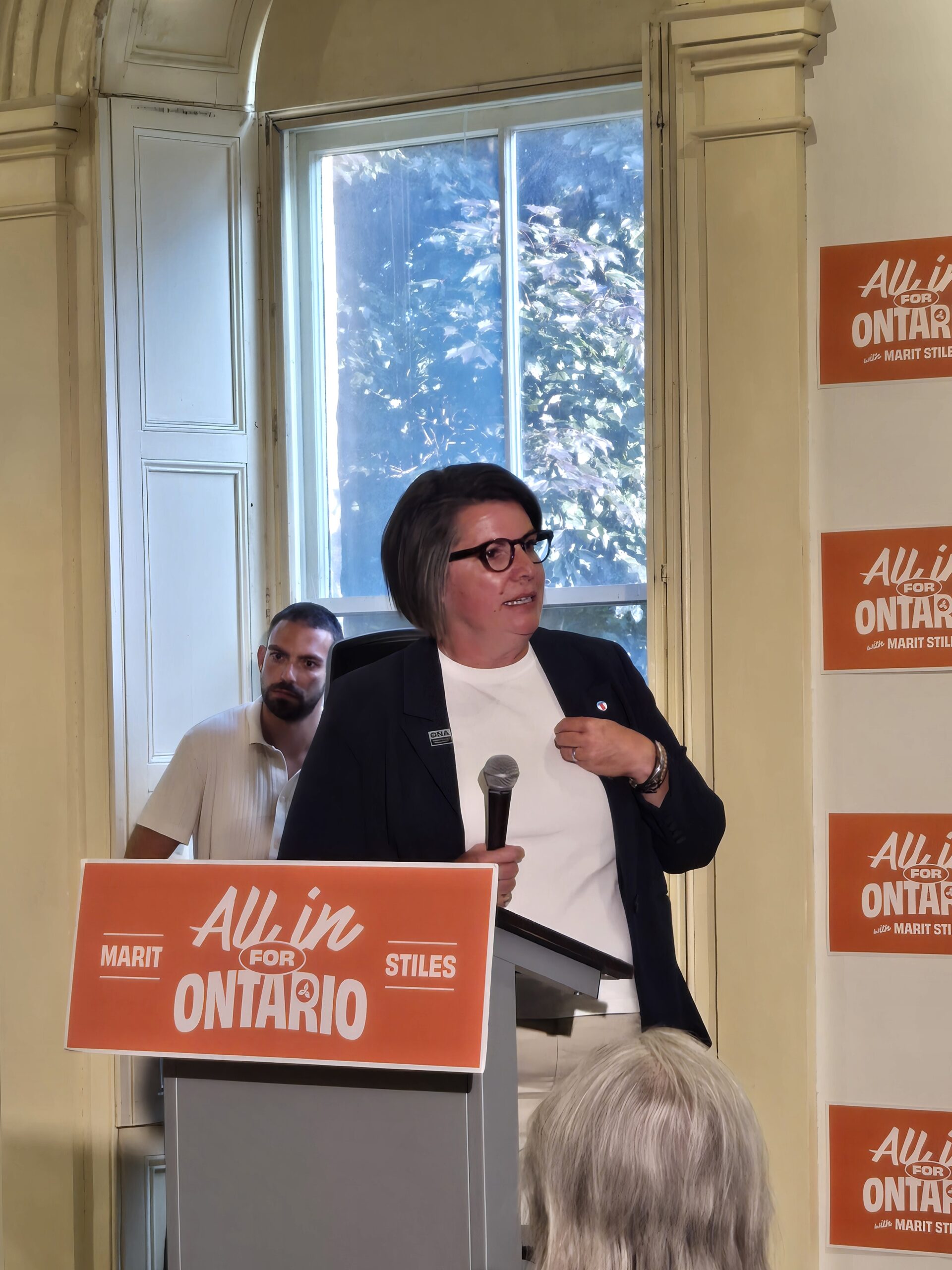 ONA President Erin Ariss talks behind a podium. 