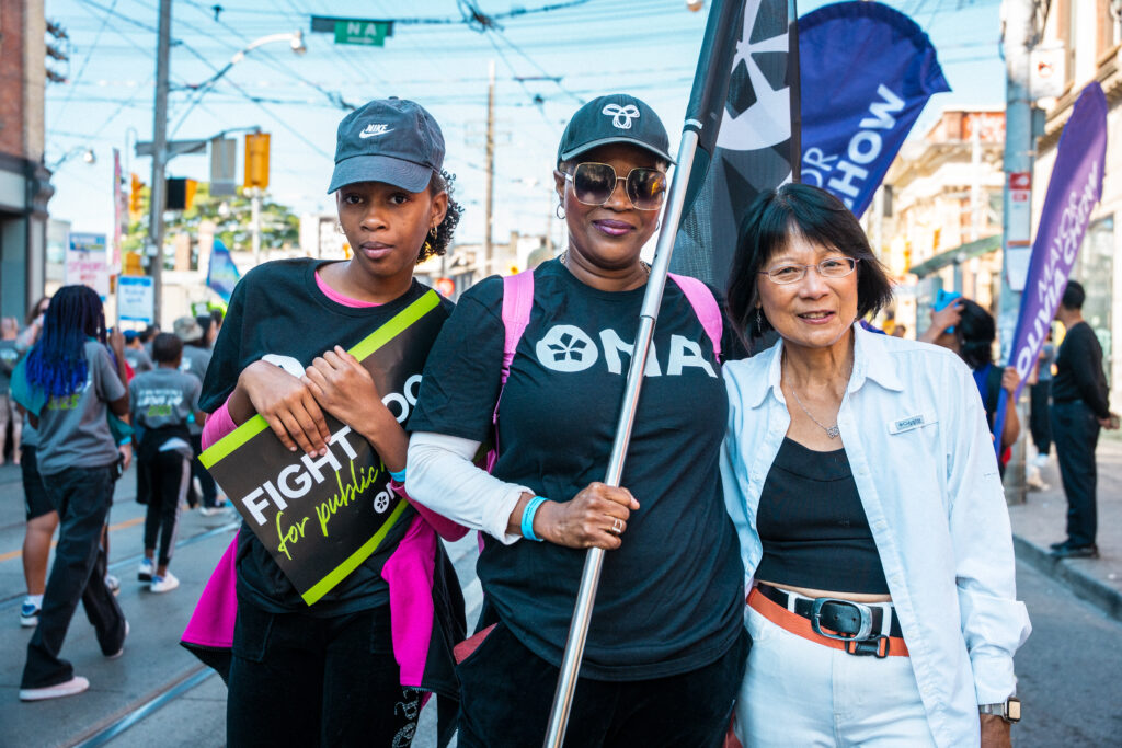 Two members pose with Toronto Mayor Olivia Chow.