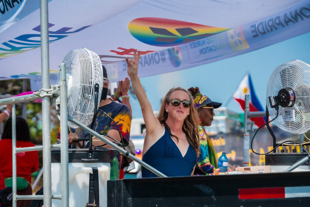 ONA board member Grace Pierias makes a peace sign as she waves to the camera.