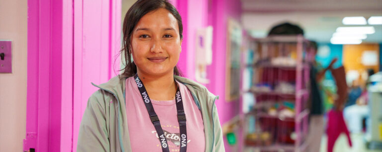 Nurse looks at the camera smiling.