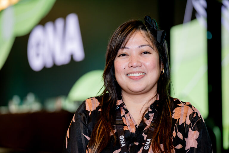 Bargaining Unit President Ghail Medaflor stands in front of ONA sign on screen at convention.