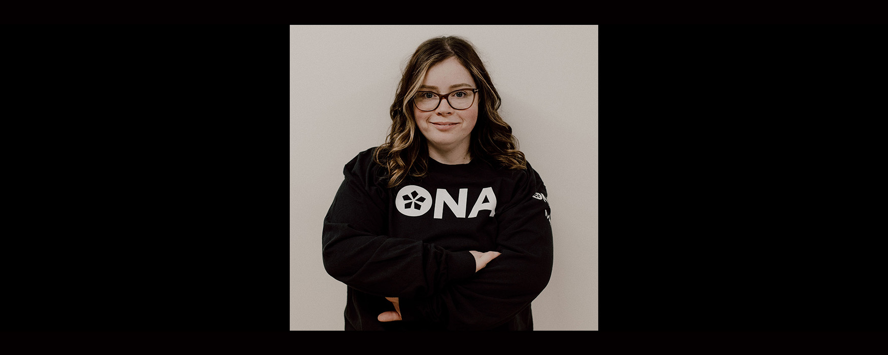 ONA and MRAT member Melissa Folz smiles while wearing ONA sweatshirt.