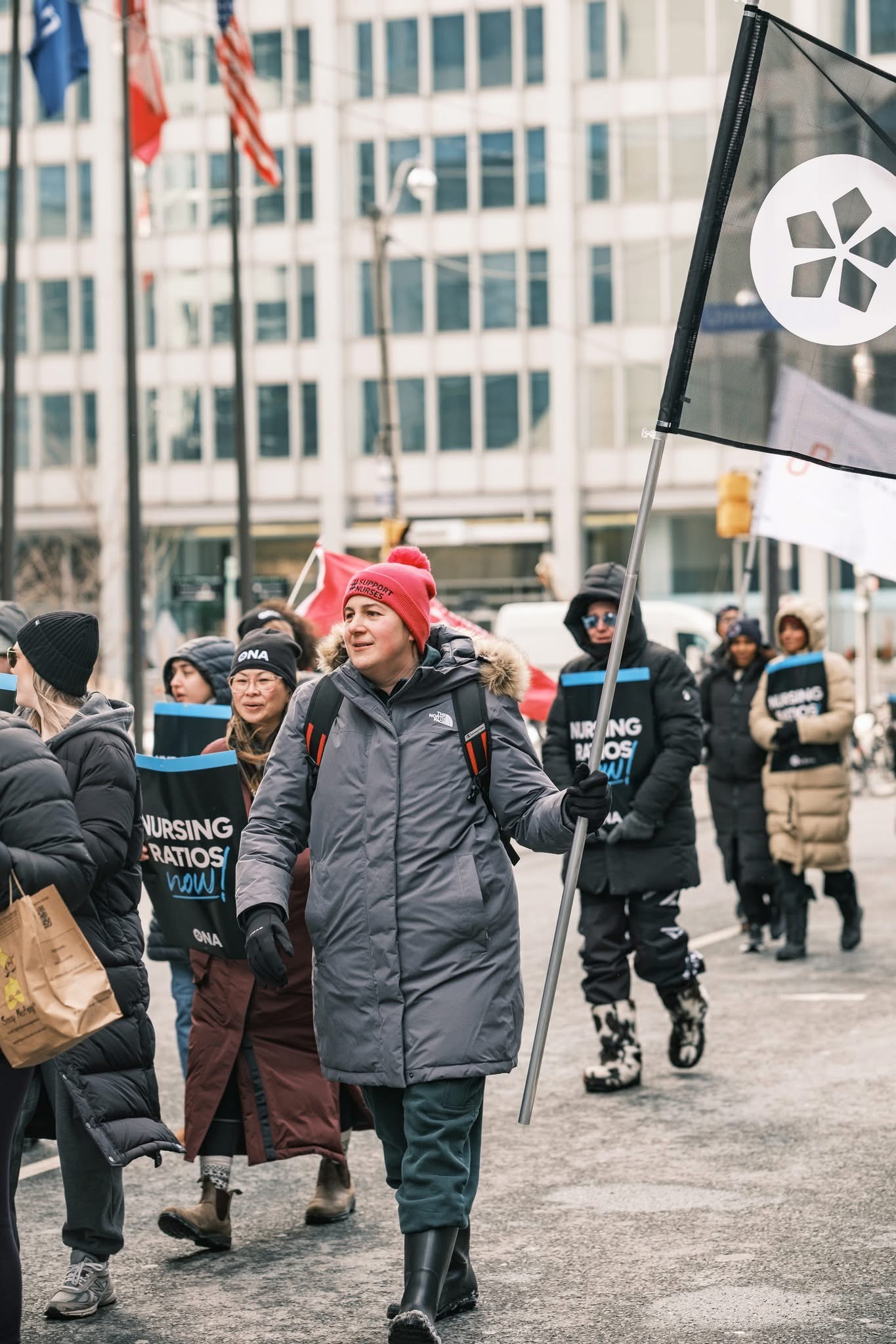ONA member Meaghan Antolin marches in a rally holding an ONA flag.
