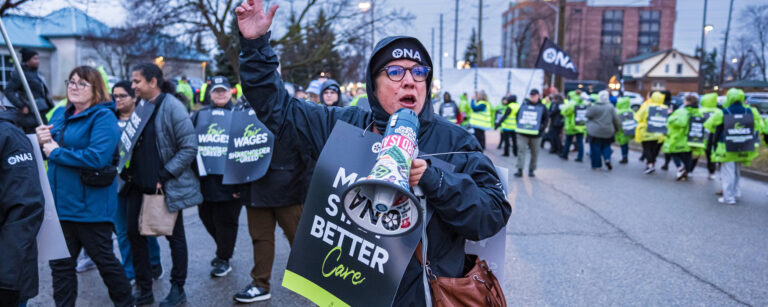 ONA Provincial President Erin Ariss yells into megaphone during rally.