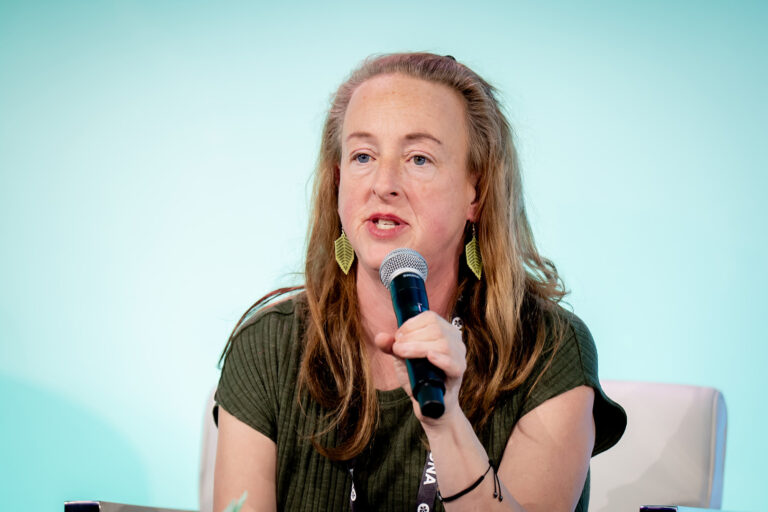 Region 4 Vice-President Grace Pierias speaks into a mic on stage. 