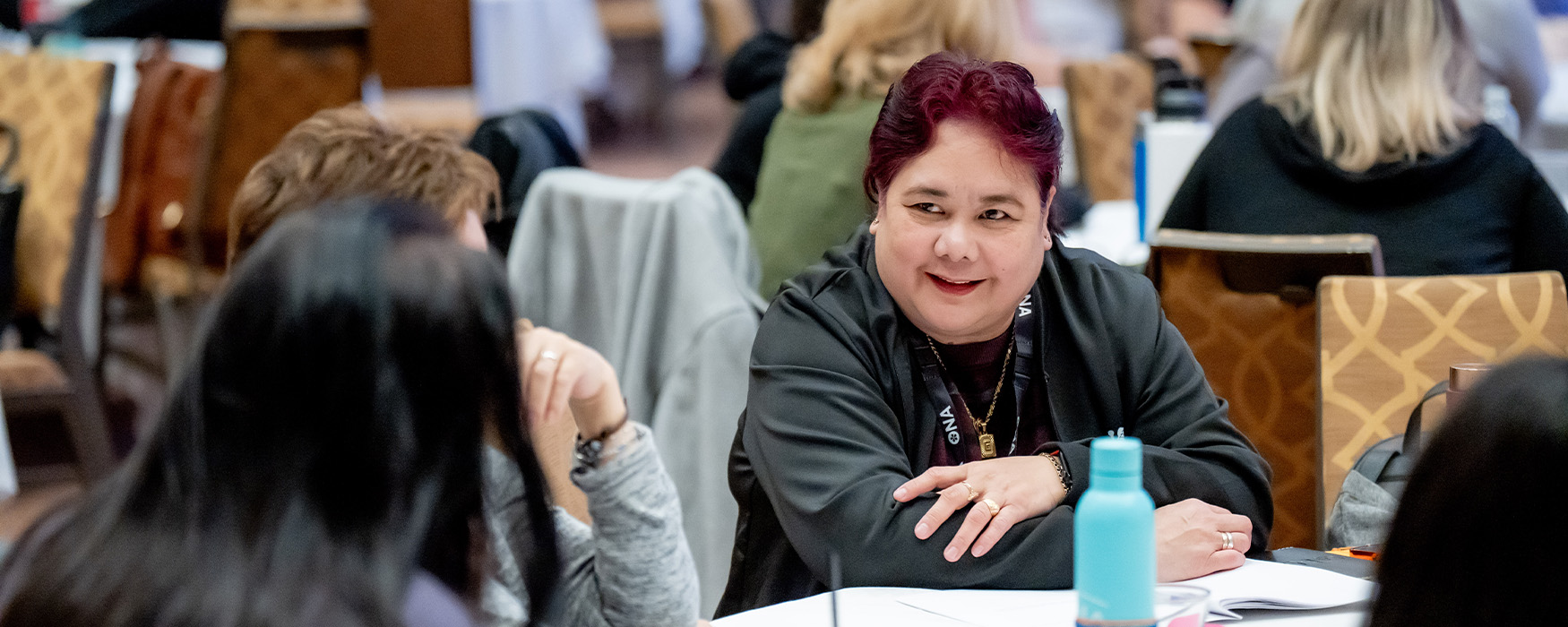 Group of members chat at a table.