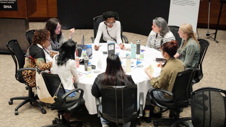 Group of members at a round table talk.