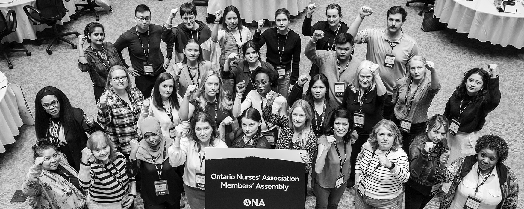 Black and white photo of group of members with fists in air.
