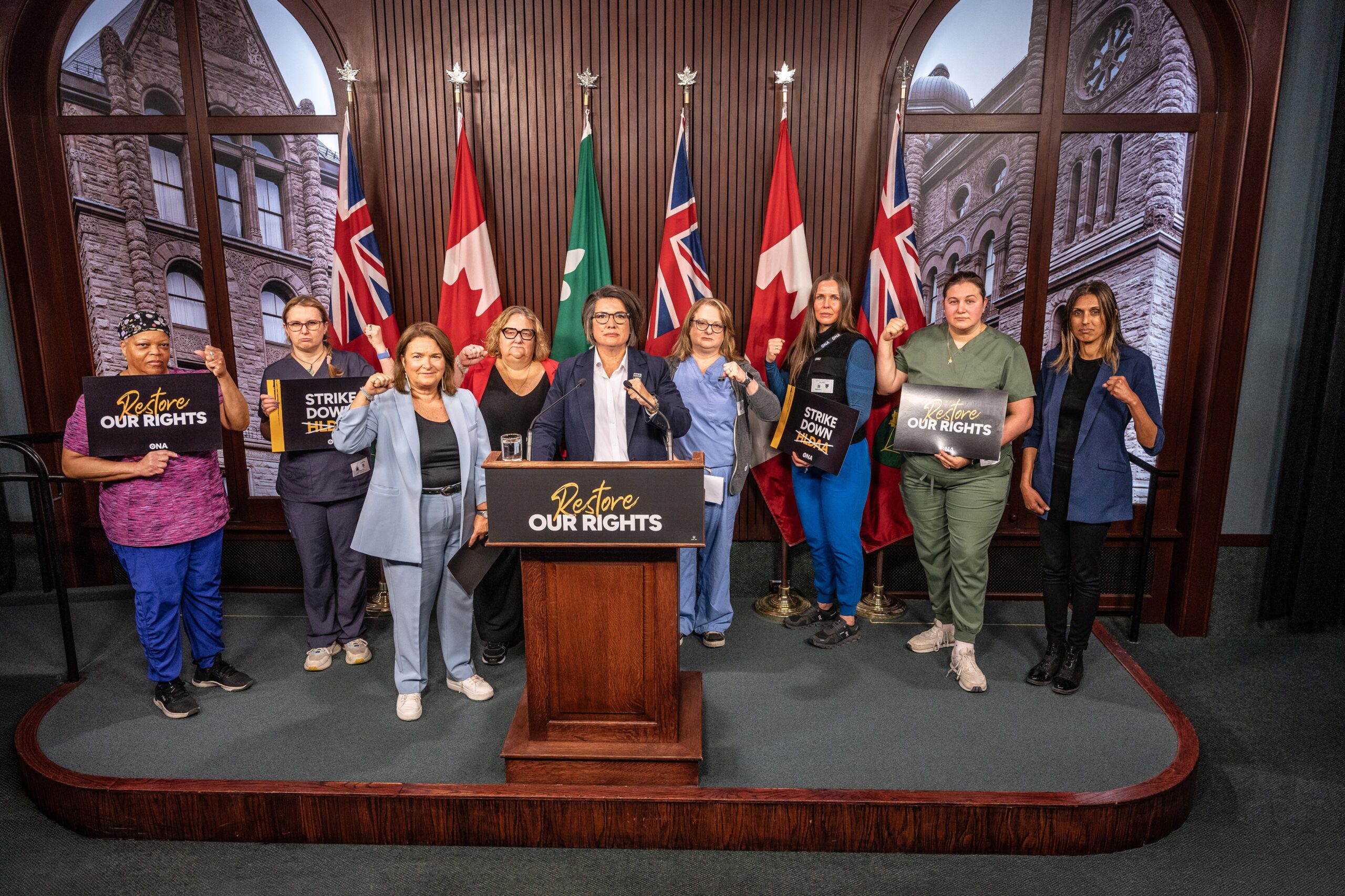 Group of ONA leaders, members and supporters fist pump at a media conference.