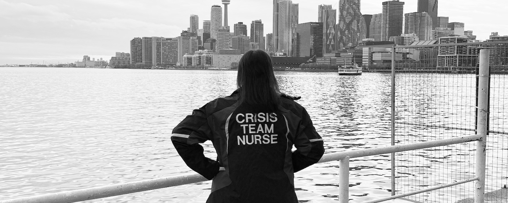ONA member Brianna Ducharme stands with back to the camera while overlooking the Toronto skyline.