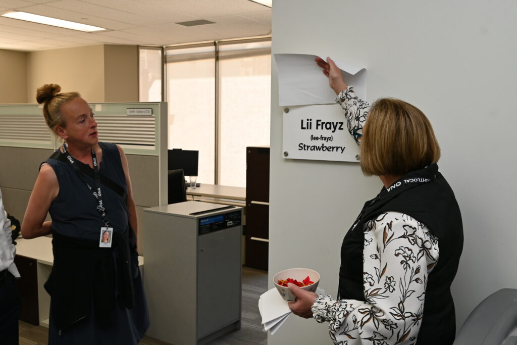 Two women look at sign reading, “Lii Frayz (Strawberry).”