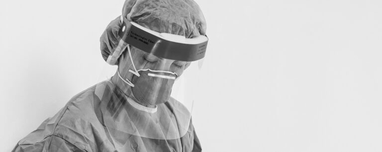 Nurse in PPE looking deflated.