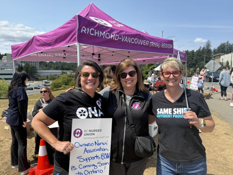 ONA Provincial President Erin Ariss, BCNU President Adriane Gear and another woman stand together during a picket.
