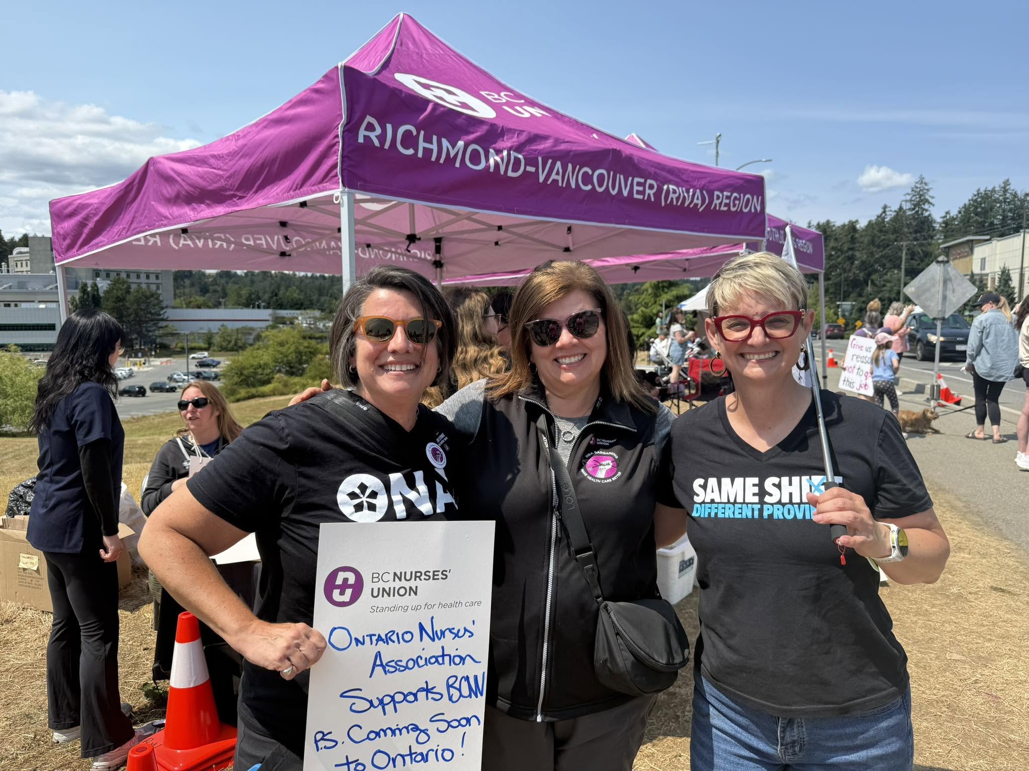 ONA Provincial President Erin Ariss, BCNU President Adriane Gear and another woman stand together during a picket.