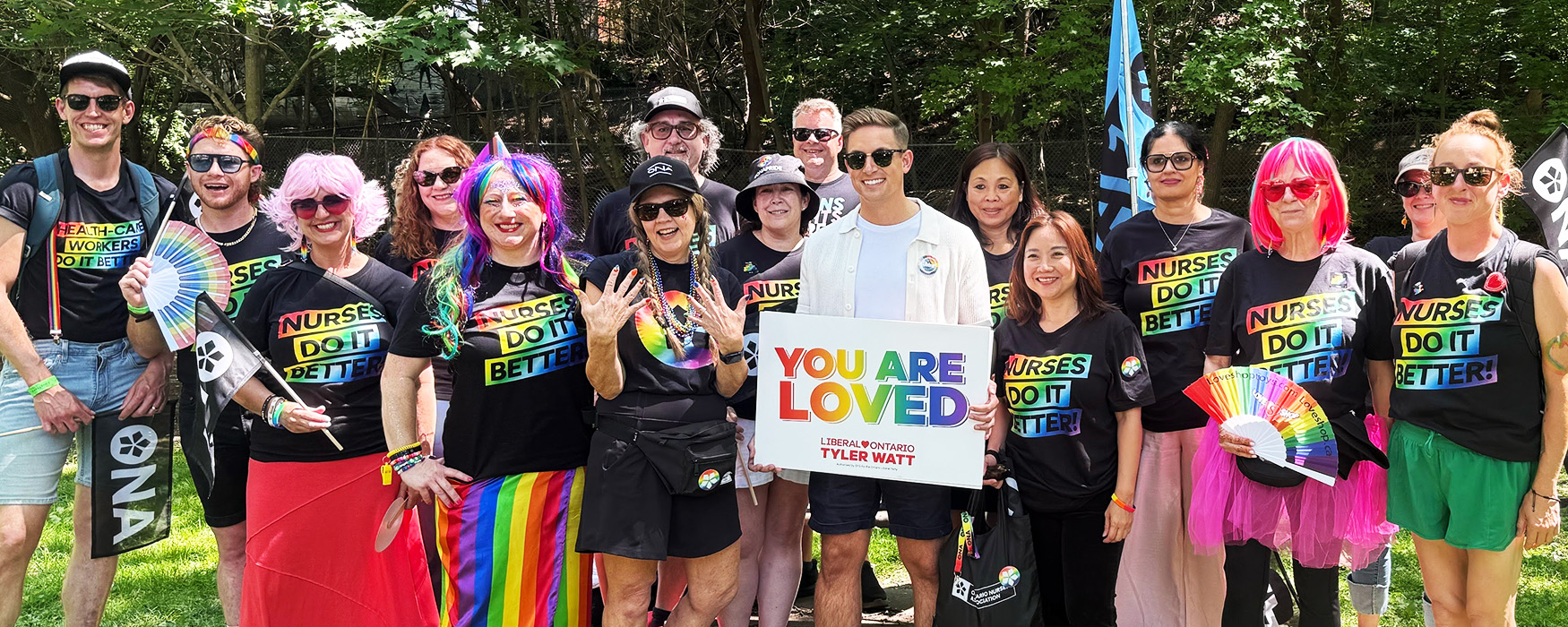 Group photo showing the ONA Pride contingent in colourful t-shirts with lots of embellishments.