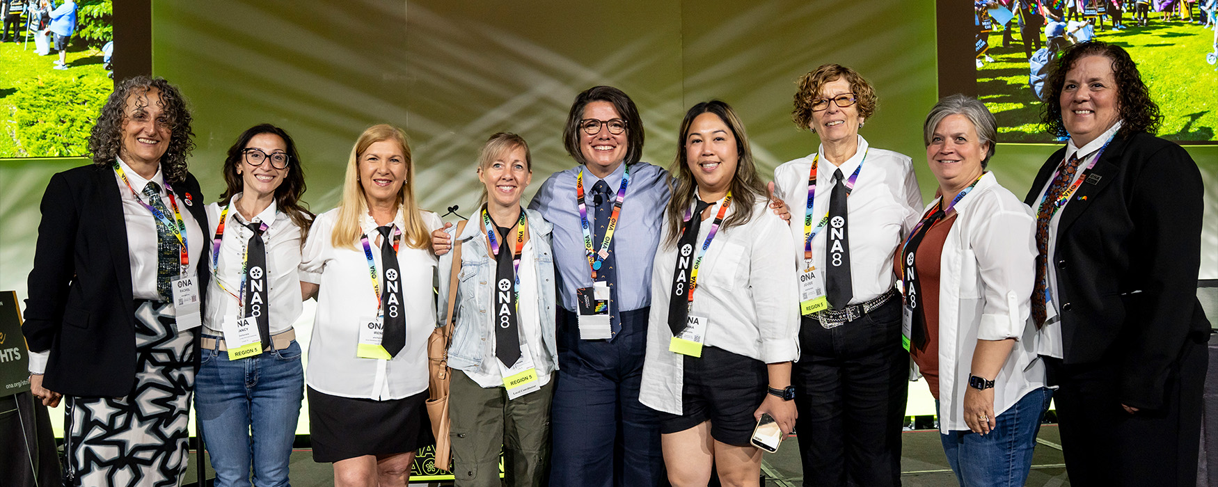 Group of Board of Director and ONA8 members standing in a row wearing ties.