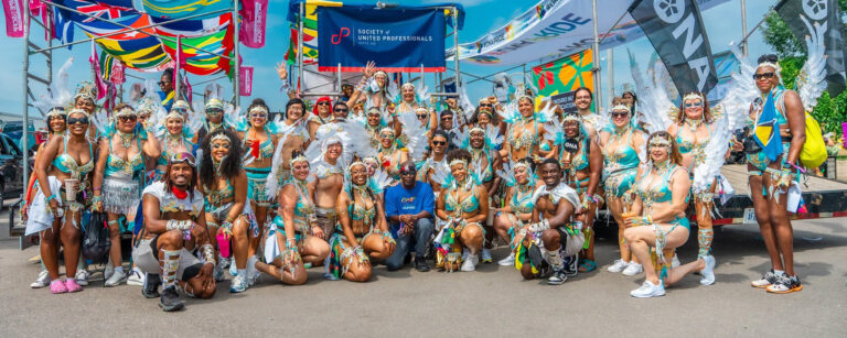 Large group shot of members dressed in colourful Toronto Caribbean Carnival costumes.