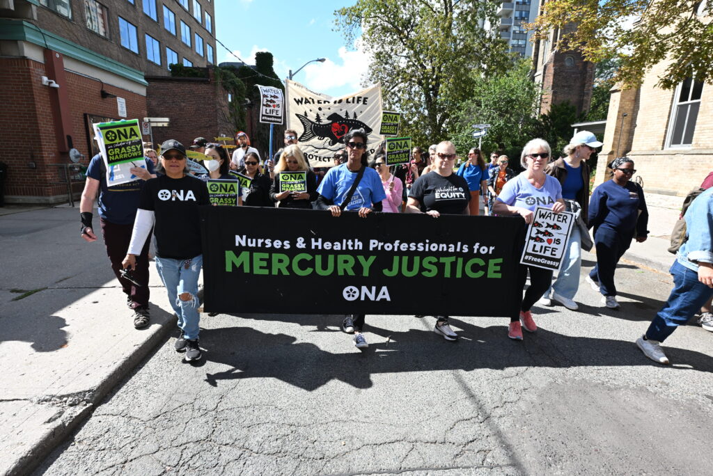 ONA members carry our banner on the streets with staff and others walking behind them.