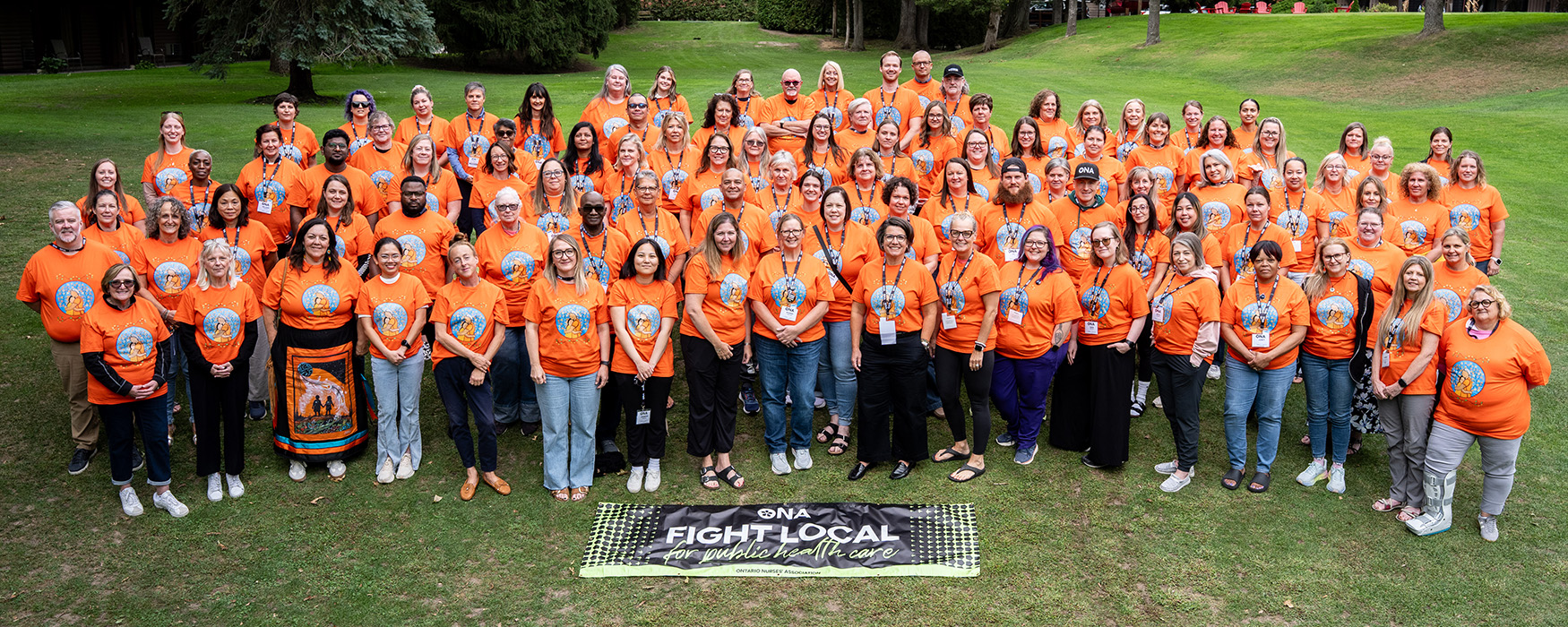 Group shot of ONA members, the Board of Directors and staff wearing orange t-shirts.